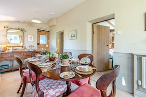A dining room with a round table set for six, surrounded by wooden chairs. - 2 Bed in Bullocks Mill (oc-p34726) (Hereford)