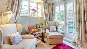 A cozy living room with a sofa, armchair, and a small table with a vase and a basket. - 2 Bed in Bullocks Mill (oc-p34726) (Hereford)