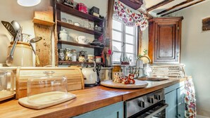 A kitchen with wooden cabinets, a countertop, a kettle, and various kitchen utensils. - 2 Bed in Bullocks Mill (oc-p34726) (Hereford)