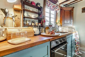 A kitchen with wooden cabinets, a countertop, a kettle, and various kitchen utensils. - 2 Bed in Bullocks Mill (oc-p34726) (Hereford)