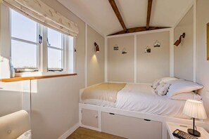 A bedroom with a bed, bedside table, lamp, and a window with curtains. - 1 Bed in Foulsham (oc-j34678) (Foulsham)