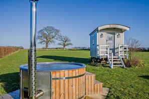 A hot tub with a metal frame, a wooden deck, and a small cabin with a ladder. - 1 Bed in Foulsham (oc-j34678) (Foulsham)