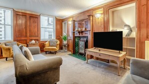 A living room with a television, sofas, and wooden paneling. - 3 Bed in Whitby (oc-l20748) (Whitby)