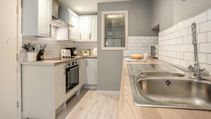A compact kitchen with white cabinets, a built-in oven, a stainless steel sink, and a window above the counter. - 3 Bed in Whitby (oc-l20748) (Whitby)