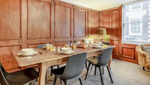 A dining area with a wooden table set for breakfast, including plates, glasses, and pastries. - 3 Bed in Whitby (oc-l20748) (Whitby)