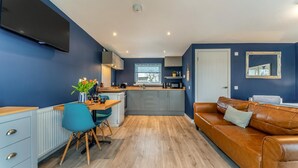 Un espacio habitable compacto con cocina, comedor y sofá.