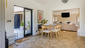 Un intérieur moderne comprenant un coin repas, un canapé et un téléviseur.