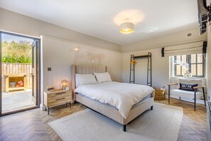 A bedroom with a bed, bedside table, lamp, and a view of the outdoors. - 2 Bed in Nantgaredig (oc-t34635) (Llanarthney)