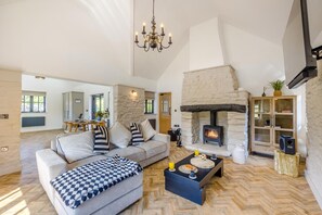 A spacious living room with a stone fireplace, a sofa set, and a coffee table.