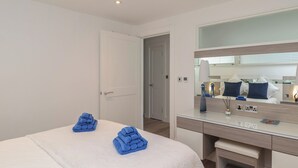 Ein Hotelzimmer mit Bett, Schreibtisch, Spiegel und Tür.
