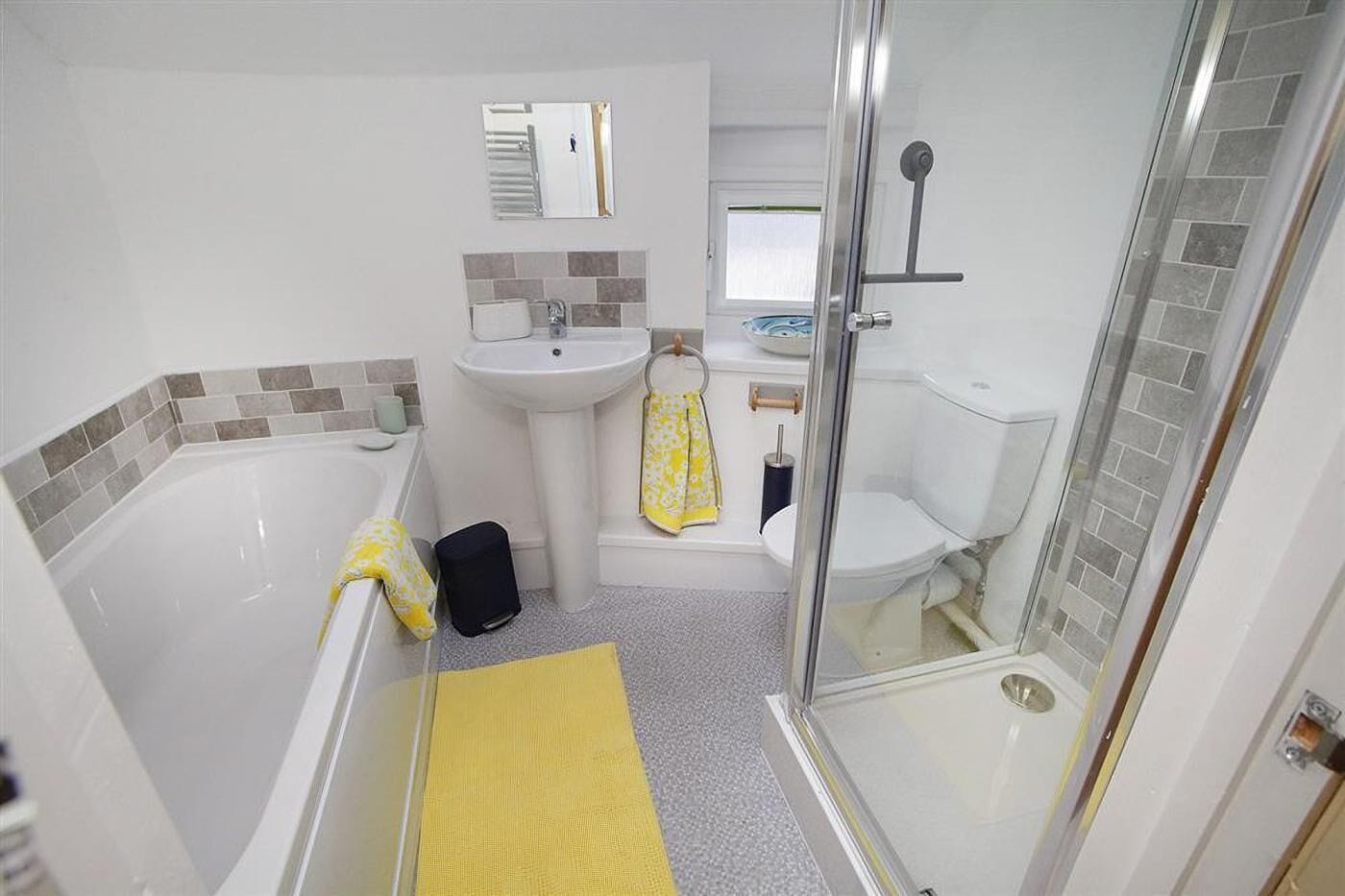 Ein Badezimmer mit Badewanne, Waschbecken, Toilette und Duschbereich.