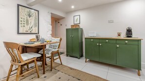 A dining area with a table, chairs, a green cabinet, and a framed botanical print on the wall. - 2 Bed in Buxton (oc-f34153) (Buxton)