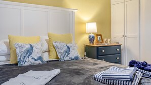 A bedroom with a bed, pillows, a bedside table with a lamp, a dresser, and a wardrobe. - 2 Bed in Buxton (oc-f34153) (Buxton)