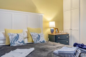 A bedroom with a bed, pillows, a bedside table with a lamp, a dresser, and a wardrobe. - 2 Bed in Buxton (oc-f34153) (Buxton)