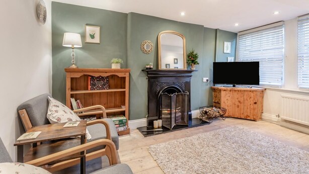A living room with a fireplace, a television, and a bookshelf. - 2 Bed in Buxton (oc-f34153) (Buxton)