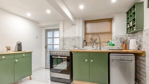 A modern kitchen with a built-in oven, dishwasher, and a window with blinds. - 2 Bed in Buxton (oc-f34153) (Buxton)