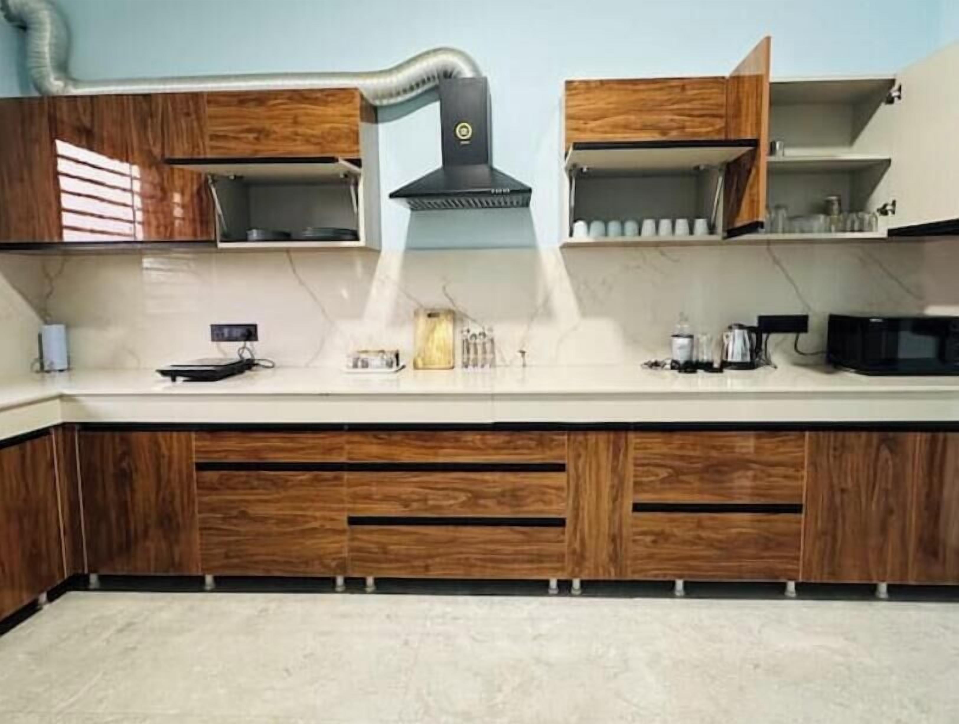 Una cucina con mobili in legno, un fornello e un forno a microonde.