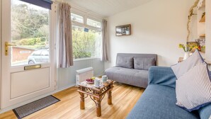 A cozy living room with a grey sofa, a wooden coffee table, and a blue couch. - 1 Bed in Caswell (oc-hh372) (Newton)