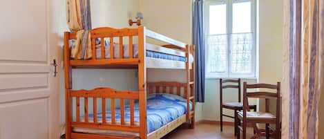 Une chambre avec un lit superposé, un bureau et une chaise.