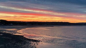 A coastal sunset with a calm sea reflecting the sky. - 2 Bed in Mumbles (oc-hh132) (The Mumbles)