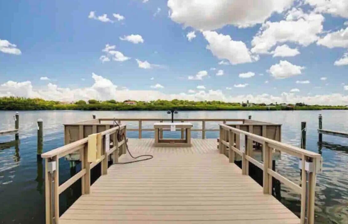 Un muelle de madera se extiende sobre aguas tranquilas, con un cielo despejado arriba.