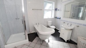 Un baño con una bañera independiente, inodoro, lavabo y cabina de ducha.
