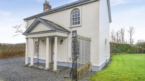 A single-story building with a porch, a gated entrance, and a clear sky. - 2 Bed in Newchapel (oc-c34717) (Clydau)