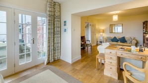 A room with a wooden desk, a bed with pillows, a bookshelf, and a door leading to an outdoor area. - 3 Bed in Dunbar (oc-k34653) (Dunbar)
