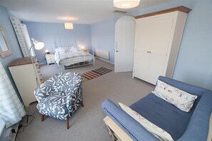 A bedroom with a bed, a chair, a wardrobe, and a desk. - 2 Bed in Mumbles (oc-hh1203) (The Mumbles)