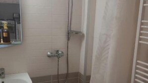 Ein Badezimmer mit Waschbecken, Dusche und Handtuchhalter.