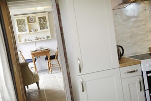 A kitchen with white cabinets, a wooden countertop, and a stove.