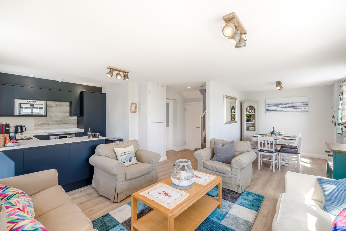 A modern living space with a kitchen, dining area, and seating.