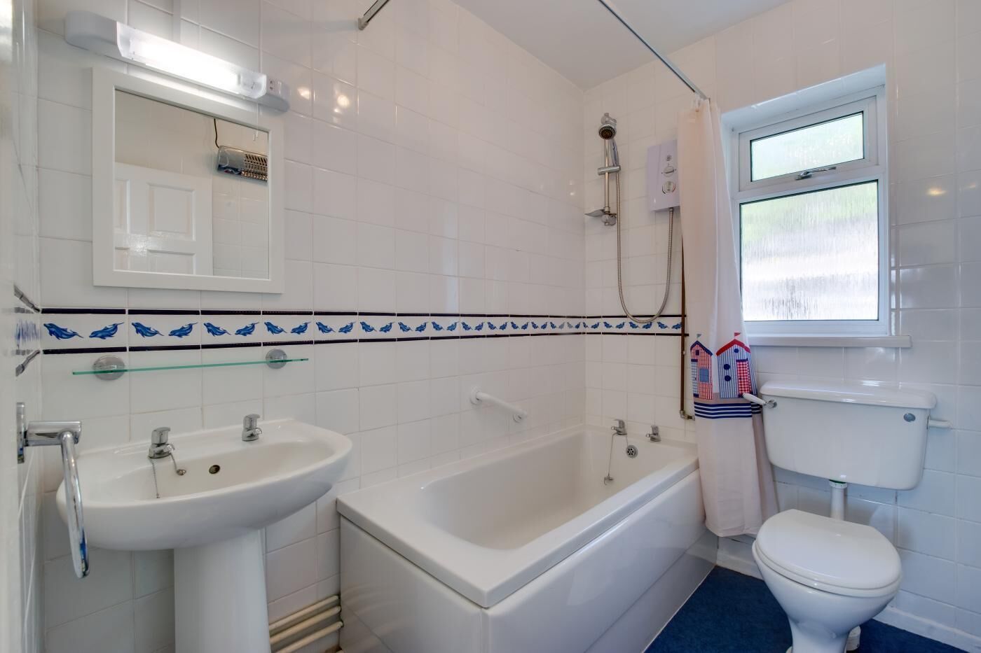 Une salle de bain avec une baignoire, un lavabo, des toilettes et une fenêtre.