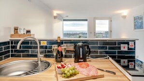 Une cuisine équipée d’un évier, d’une machine à café et d’une fenêtre donnant sur un beau paysage.