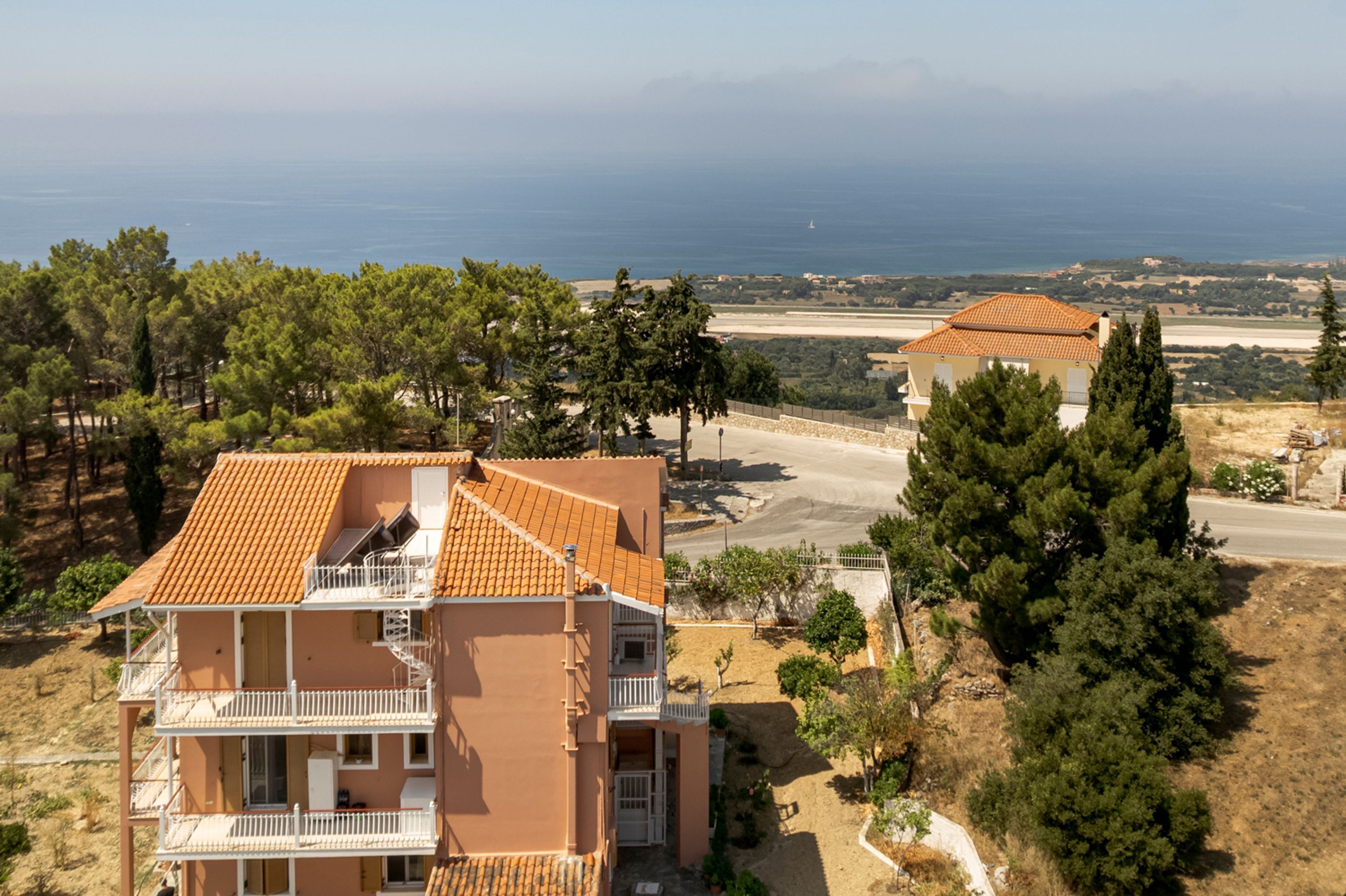 Un edificio a più piani con balconi, vista sul mare e un paesaggio sabbioso.