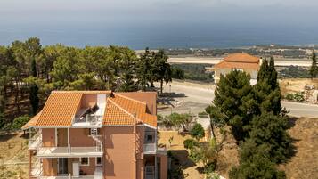 Un edificio a più piani con balconi, vista sul mare e un paesaggio sabbioso.