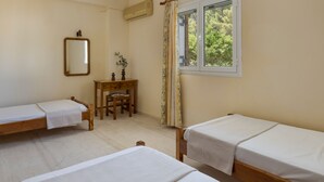 A room with two single beds, a wooden desk with a chair, a mirror, and a window with curtains. - Apartment for 5 Second Building (Lakithra)