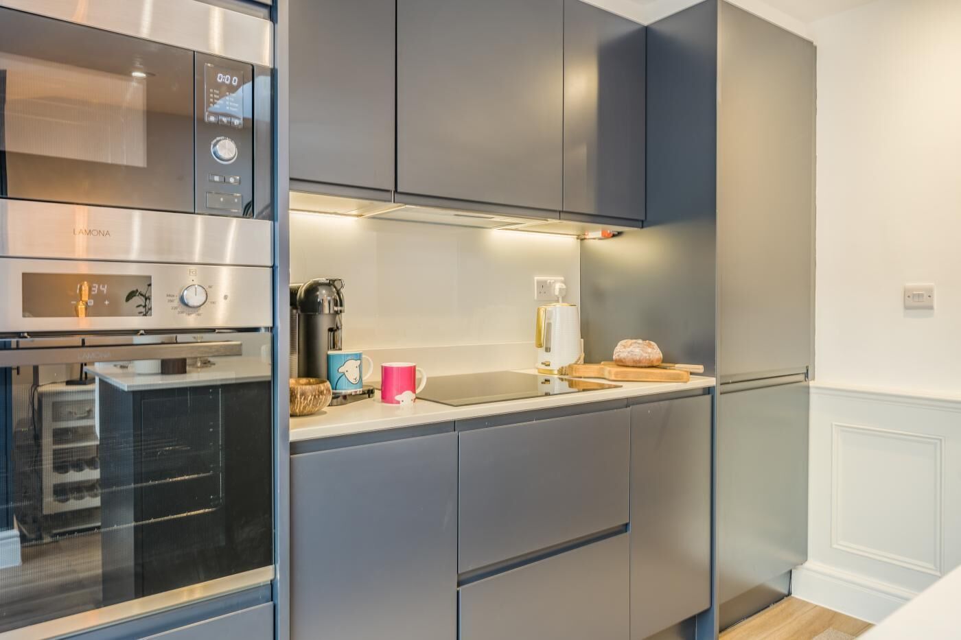 A modern kitchen with stainless steel appliances, a coffee maker, and a toaster on the counter.