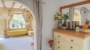Una habitación con cama, cómoda, espejo y ventana con cortinas.