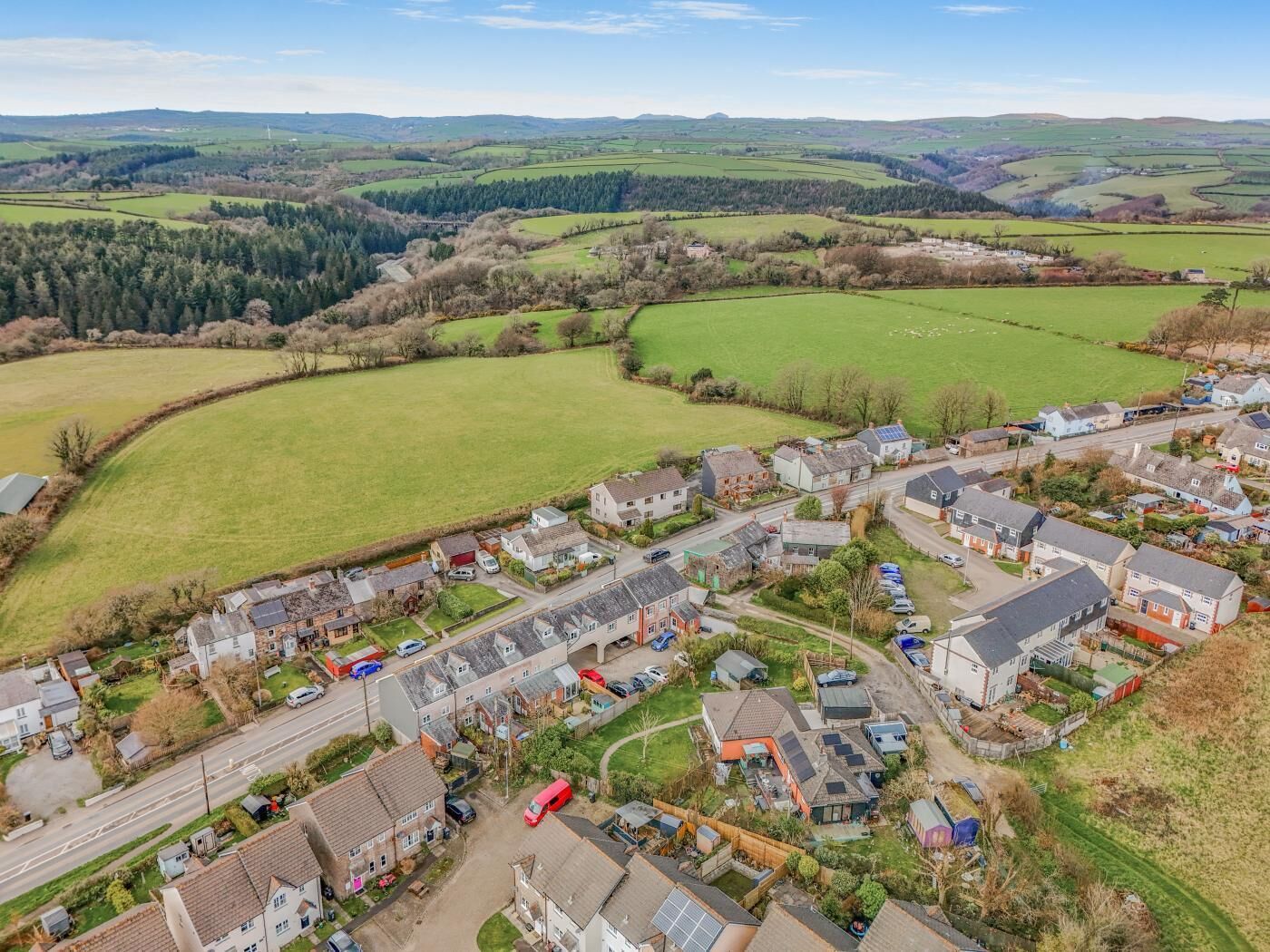 A rural village with houses, roads, and fields.