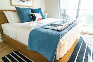 Ein Bett mit einer blauen Steppdecke, weißen Kissen und einer blauen Tagesdecke.