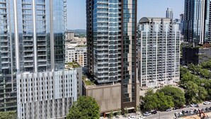 A high-rise building with multiple floors, large windows, and a modern architectural design. - King Retreat/Rooftop Views/Rainey/UT/Moody/6th St (Austin)