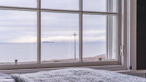 A room with a large window, a bed, and a rug. - 3 Bed in Dysart (oc-p34376) (Dysart)