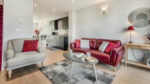 Ein modernes Wohnzimmer mit einer Couch, einem Couchtisch und einem roten Ledersofa.