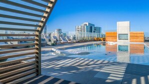 A rooftop pool with clear blue sky, modern architecture, and lounge chairs. - Modern Luxury Downtown, Mins to Everything (Austin)