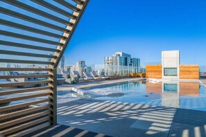 A rooftop pool with clear blue sky, modern architecture, and lounge chairs. - Modern Luxury Downtown, Mins to Everything (Austin)