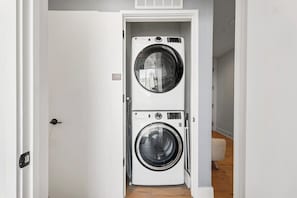 A laundry room with two stacked washing machines. - 3004 ATX Corner Premium Suite | Rooftop Pool, Skyline Views & Rainey St (Austin)