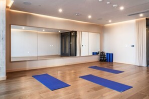 A room with a large mirror, wooden flooring, and blue mats. - Corner Premium Downtown Suite * Rooftop Pool (Austin)