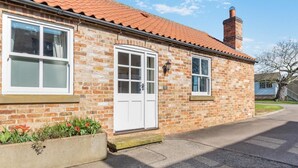 A two-story stone house with a red-tiled roof, a white front door, and a chimney. - 2 Bed in Kirkby Green (oc-s34761) (Kirkby Green)