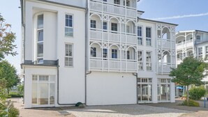 Een meerlaags gebouw met balkons, grote ramen en een symmetrische gevel.